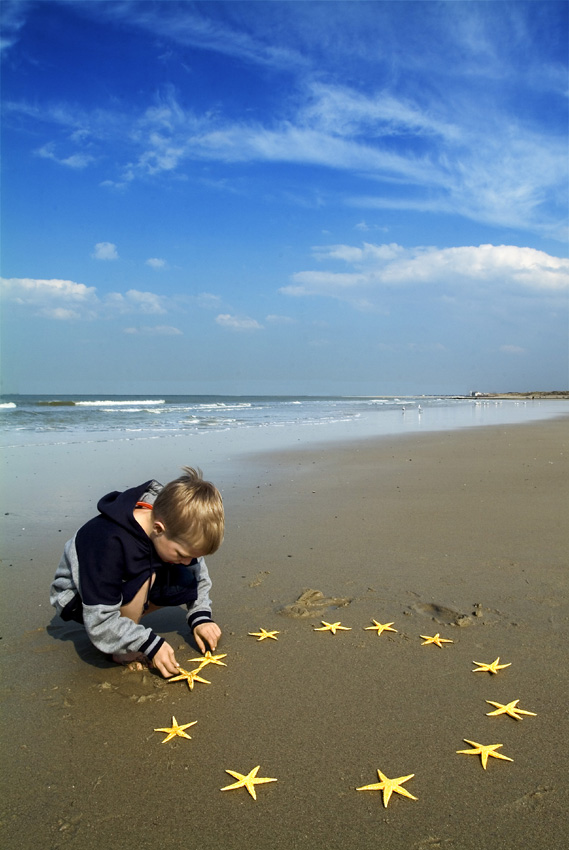 photo of boy on beach arranging the 12 EU stars in a circle
