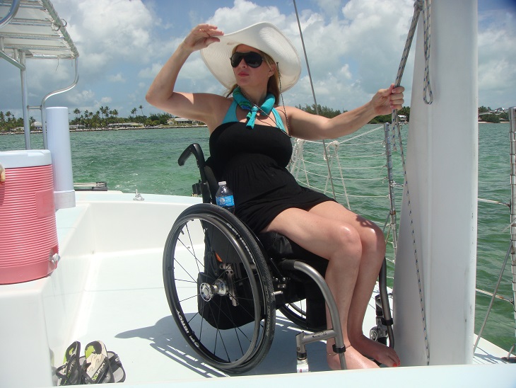 Image of lady wheelchair user on a sailboat looking to the distance