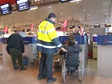 photo of airport assitant and wheelchair user at check-in