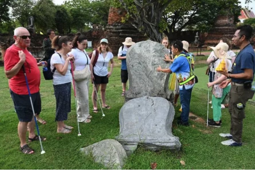 Photo: A group of blind visitors at a heritage site on a tour with Accessible Thailand Tours staff