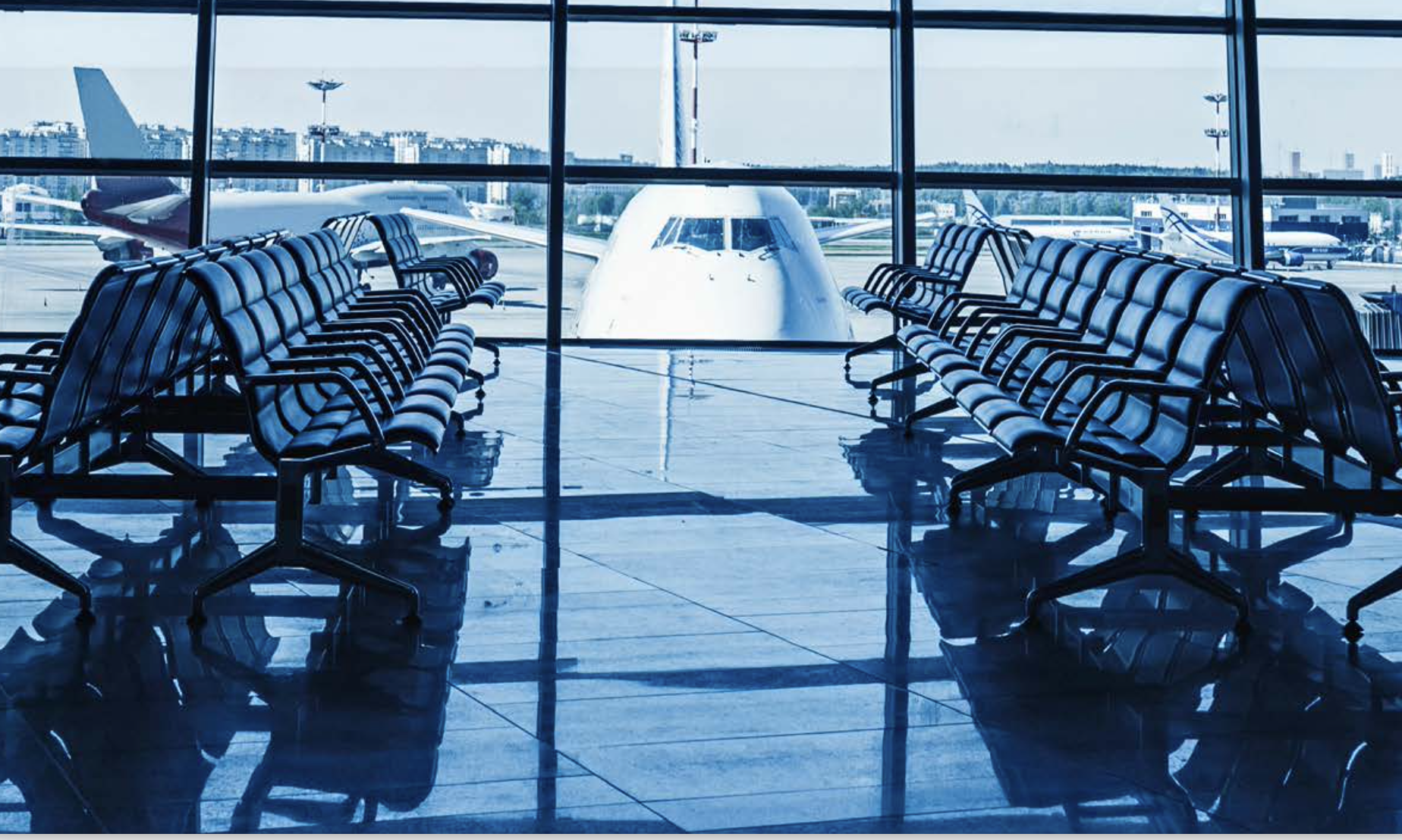 Airport waiting area with empty seats with large window and plane on stand-UNWTO-Alberto-G- Uceda